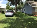 Spacious side yard with green grass surrounding the house and additional detached storage on the property at 1010 Dakota Ave, St Cloud, FL 34769