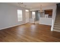Bright, open living room with hardwood floors, a staircase, and view into the adjacent kitchen at 1034 Enclair St, Orlando, FL 32828
