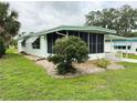 Light green home featuring a large screened-in porch at 106 Azalea Trl, Leesburg, FL 34748