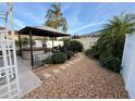 Lush backyard with a luxurious hot tub under a gazebo, surrounded by tropical plants and a stone pathway at 1130 Pelion Pl, The Villages, FL 32162