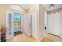 Inviting foyer with light wood floors, coat closet and arched window above the door at 115 Henue Ct, Davenport, FL 33896