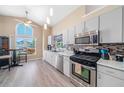 Bright kitchen features stainless steel appliances, tile backsplash, eat-in nook and backyard views at 115 Henue Ct, Davenport, FL 33896