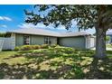 Beautiful home with mature tree providing shade on the lush green lawn, creating a serene ambiance at 130 Evergreen Dr, Auburndale, FL 33823