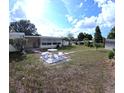Spacious backyard featuring a patio table, mature trees, and ample space for outdoor activities at 15 Ne 63Rd Ct, Ocala, FL 34470