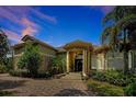 Elegant home featuring a tile roof, stone accents, lush landscaping, and a circular driveway at 1502 Hempel Ave, Windermere, FL 34786