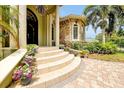 Welcoming front entrance with stone accents, curved steps, and colorful potted flowers at 1502 Hempel Ave, Windermere, FL 34786