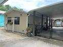 View of the property showcasing its covered parking and cozy exterior at 24505 Snail Rd, Astor, FL 32102