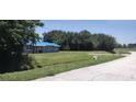 Lovely single-story home with gray paint and a blue tarp roof surrounded by a green lawn and shady trees at 2822 S Dean Rd, Orlando, FL 32825