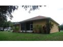 Exterior shot of the home with a screened-in lanai, green lawn, and minimal landscaping at 2913 Deerbrook Dr, Lakeland, FL 33811