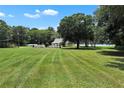 Spacious front yard with a charming home, lush green lawn, and picturesque trees, offering a serene setting at 3450 Ohio Ave, Sanford, FL 32773
