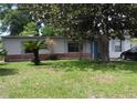 Charming single-story home featuring light-colored siding, light blue shutters, a bright blue door, and a well-maintained front lawn at 360 Kentia Rd, Casselberry, FL 32707