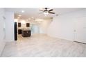 Bright, open-concept living area with recessed lighting, neutral tile flooring, and ceiling fan at 3850 Hampstead Ln, Lakeland, FL 33810