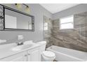 Bathroom features a modern vanity, tub, and tiled shower, enhanced by natural light at 5390 Botany Ct, Orlando, FL 32811