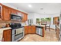 Well-lit kitchen with granite countertops, stainless steel appliances, and wooden cabinetry at 615 Maple Forest Dr, Orlando, FL 32825