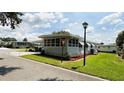Well-maintained single-story home with green lawn, mulched beds, and a corner view at 103 Poinsettia Cv, Leesburg, FL 34748