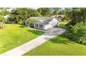 Aerial view of a well-maintained home with a long driveway, attached garage, and lush green lawn at 1330 Englewood Dr, St Cloud, FL 34772