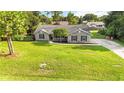 Charming single-story home with brick facade, dark shutters, manicured lawn, and mature tree in front at 1330 Englewood Dr, St Cloud, FL 34772