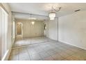 Spacious living room with tile flooring, large mirror wall and chandelier lighting at 310 Dagama Ct, Kissimmee, FL 34758