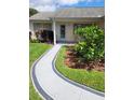 Close up on front yard with walkway leading to the front door and lush, well-maintained landscaping at 527 San Pedro Dr, The Villages, FL 32159