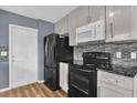 Updated kitchen with black appliances, stylish backsplash, and ample cabinet space at 5806 Fernhill Dr, Orlando, FL 32808