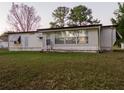 Single-wide mobile home with a large window and grassy yard at 4775 Hunting Lodge Dr, Saint Cloud, FL 34772