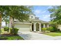 Two-story house with a green exterior, attached garage, and lush landscaping at 5144 Oakbourne Ave, Davenport, FL 33837