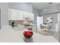 Well-lit kitchen with white cabinetry, modern appliances, and an adjacent breakfast nook area at 705 Ashton Dr, Davenport, FL 33837