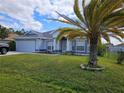 Lovely home with a lush lawn, mature palm tree, and an attached garage, blending comfort and style at 959 Nancy Ct, Kissimmee, FL 34759