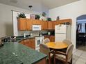 Functional kitchen with wood cabinets, green counters, and cozy breakfast nook at 959 Nancy Ct, Kissimmee, FL 34759