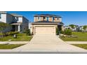 Well-manicured lawn leads up to this tan two-story home with a tan garage at 1134 Forest Gate Cir, Haines City, FL 33844