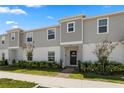 Two-story townhome with gray siding, landscaping, and a paved walkway at 1330 Blazing Star Ln, Davenport, FL 33837
