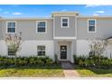 Two-story townhome with gray siding, landscaping, and a brick walkway at 1330 Blazing Star Ln, Davenport, FL 33837