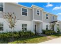 Two-story townhome with gray siding, landscaping, and a brick walkway at 1330 Blazing Star Ln, Davenport, FL 33837
