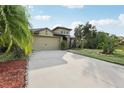 Inviting home exterior with a long driveway, lush landscaping, and a charming stone facade at 2703 Gullane Ct, Kissimmee, FL 34746