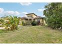 A beautifully landscaped home with stone details, a well-kept lawn, and tropical foliage at 2703 Gullane Ct, Kissimmee, FL 34746