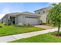 Well-manicured front yard featuring a lush lawn, brick driveway, and a modern two-story home at 3200 Songbird Cir, Harmony, FL 34773