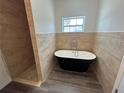 Modern bathroom featuring a sleek, black freestanding tub and a separate tiled shower space at 5115 Old Highway 37, Lakeland, FL 33811