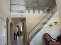 Bright foyer featuring high ceilings, staircase with decorative railing, and views to the upstairs hallway at 1387 Lexington Ave, Davenport, FL 33837