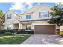 Beautiful two-story home showcasing a brick driveway, neutral colors, and a well-maintained lawn at 1387 Lexington Ave, Davenport, FL 33837