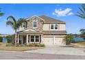 Two-story home with stone exterior, two-car garage, and a landscaped yard at 507 Natural Bridge Ct, Apopka, FL 32703