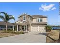 Two-story home with stone and siding, two-car garage, and lake view at 507 Natural Bridge Ct, Apopka, FL 32703