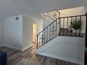 An ornate staircase is the focus with railing and a view of the bathroom at 6062 N Village Cir # Ge, Orlando, FL 32822