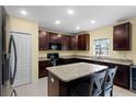 Spacious kitchen featuring granite countertops and dark brown cabinets at 520 Pinecrest Loop, Davenport, FL 33837