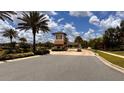 Picturesque gated community entrance with a charming guardhouse, lush palm trees, and well-maintained landscaping at 1515 Carey Palm Cir, Kissimmee, FL 34747