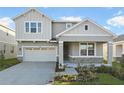 Two-story house with gray siding, stone accents, and a two-car garage at 2930 Sharp Rd, Kissimmee, FL 34744