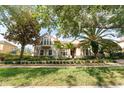 Tan house with lush landscaping and palm trees in the front at 9210 Southern Breeze Dr, Orlando, FL 32836