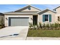 Tan house with gray garage door and teal shutters at 918 Heirloom Dr, Haines City, FL 33844