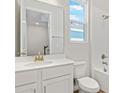 Bright bathroom features a white vanity, a shower-tub combo with white tile, and a window at 1635 Sugarbelle Cir, Mascotte, FL 34753