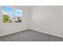 Clean, carpeted bedroom with a large window offering plenty of natural light and views of the outdoors at 1635 Sugarbelle Cir, Mascotte, FL 34753