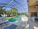 Inviting screened-in pool area with ample seating and lush greenery, perfect for outdoor relaxation at 3075 Barbados Ln, Haines City, FL 33844